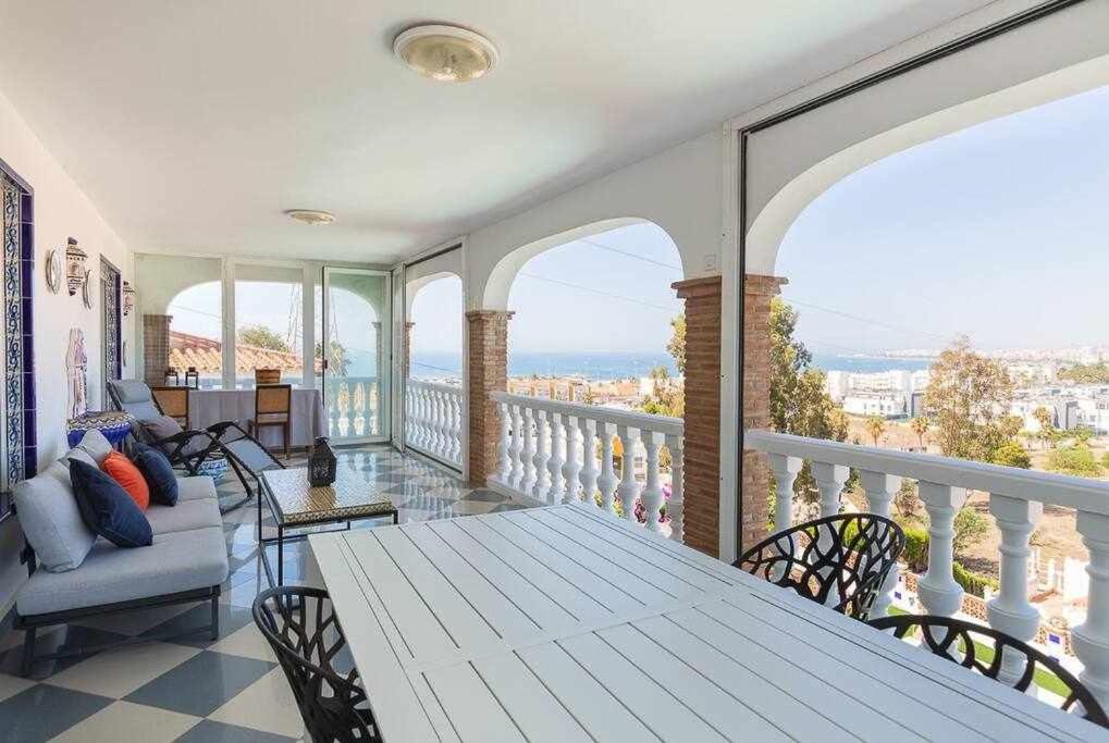 卡莱塔德贝莱斯Villa María con Piscina playa y vistas的阳台的门廊配有桌椅