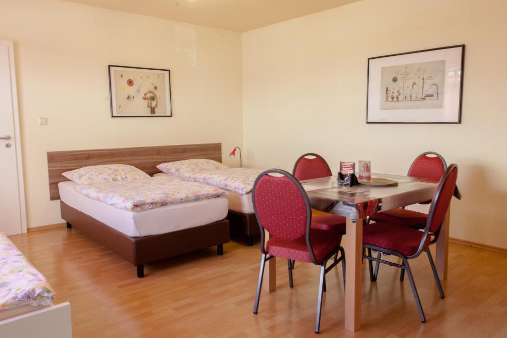 莱比锡克林根街23号膳食公寓酒店的配有一张床和一张桌子及椅子的房间