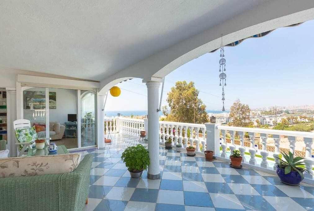 卡莱塔德贝莱斯Caleta del Sol con piscina terraza y playa的带有盆栽植物阳台的房子