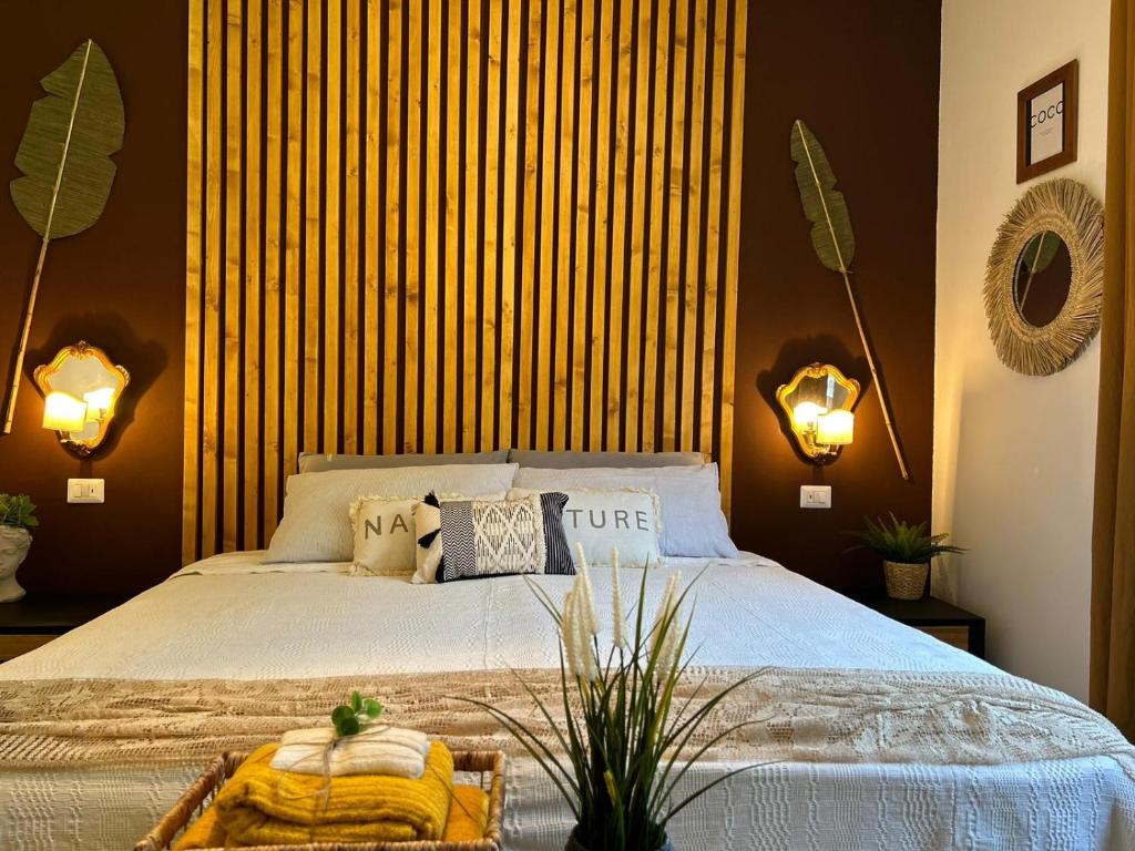 切雷西奥港TROPICAL HOME PORTO CERESIO的一间卧室配有一张大床和两个灯