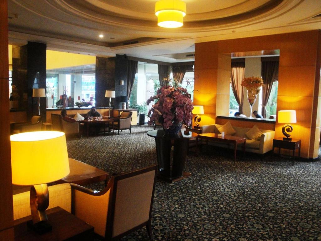美娜多美娜多品质酒店的一个带沙发和花瓶的大堂