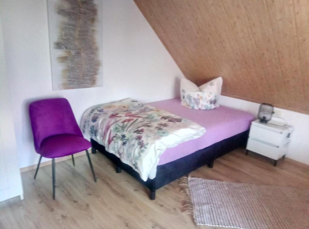 NeudörflesStadler Ferienwohnung的一间卧室配有紫色的床和紫色椅子