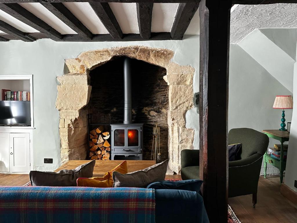 莱奇莱德Cosy Cottage in Lechlade的客厅设有石制壁炉和沙发。