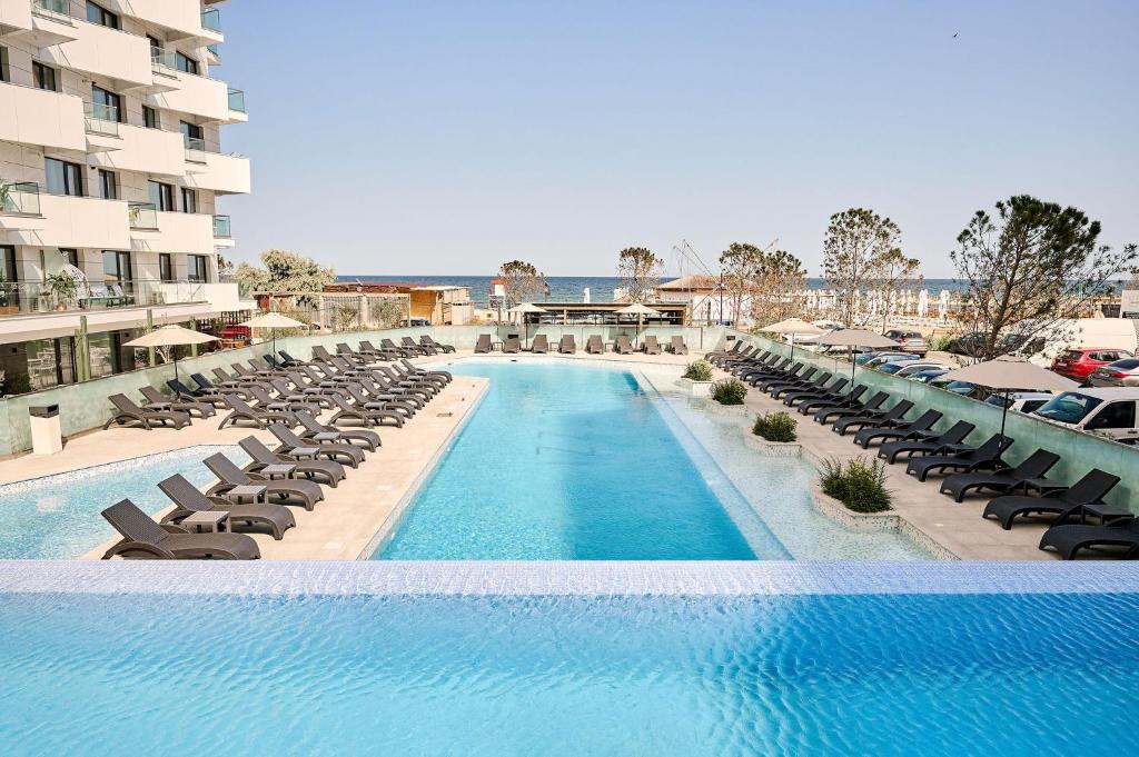 马马亚Vlezal Apartment Spa&Pool Beach Resort的一个带躺椅和椅子的游泳池