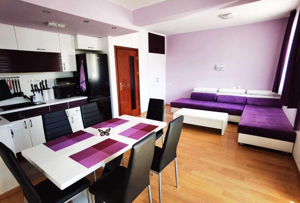 潘波洛沃Апартамент 204 Студенец的厨房以及带桌子和紫色椅子的客厅。