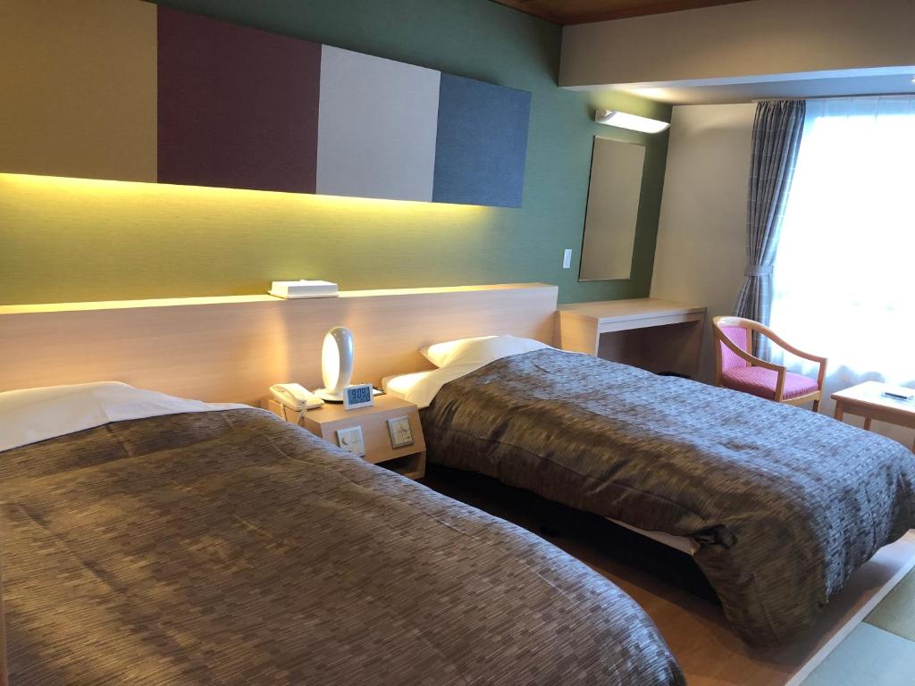 雾岛市雾岛酒店的酒店客房设有两张床和窗户。