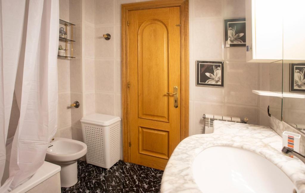 温克拉Apartamento Venecia的一间带卫生间和木门的浴室