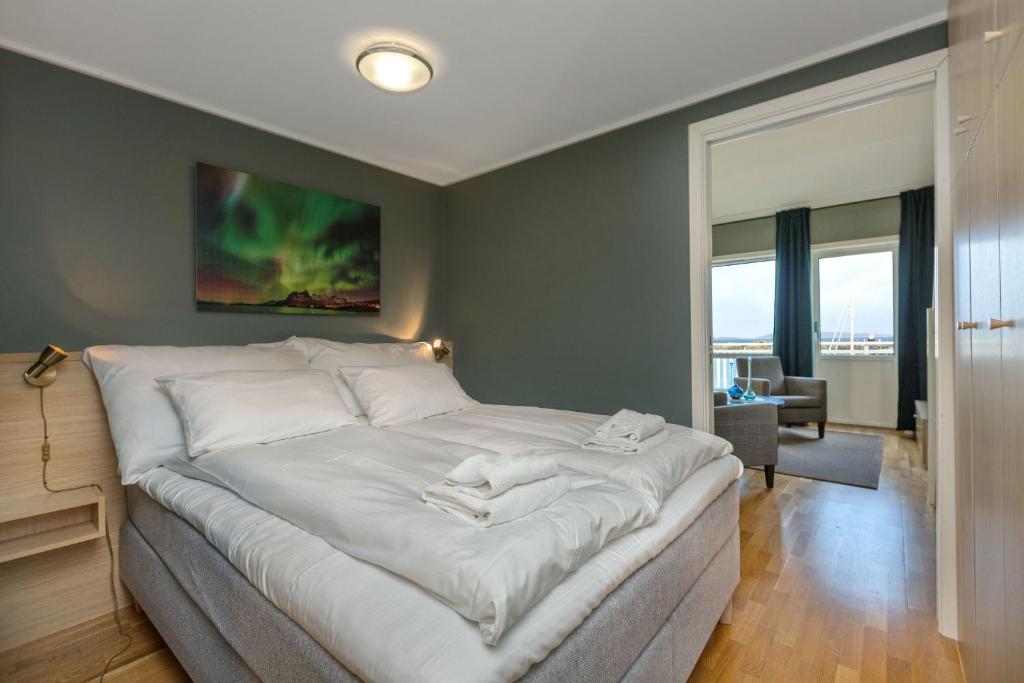 波多Kjerringøy Bryggehotell的一间卧室配有一张带白色床单的大床