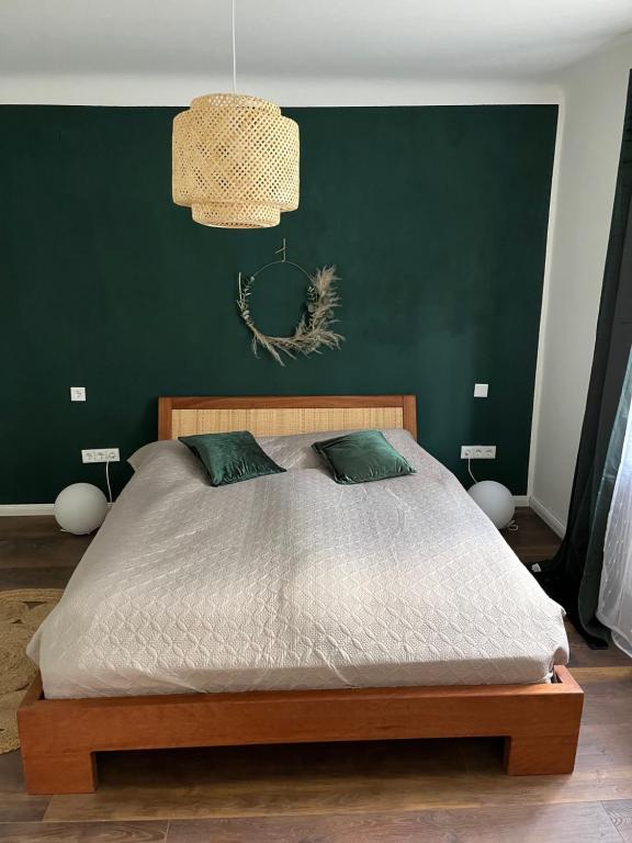 蒙绍MON Bijou 2 Schlafzimmer的一间卧室设有一张大床和绿色的墙壁