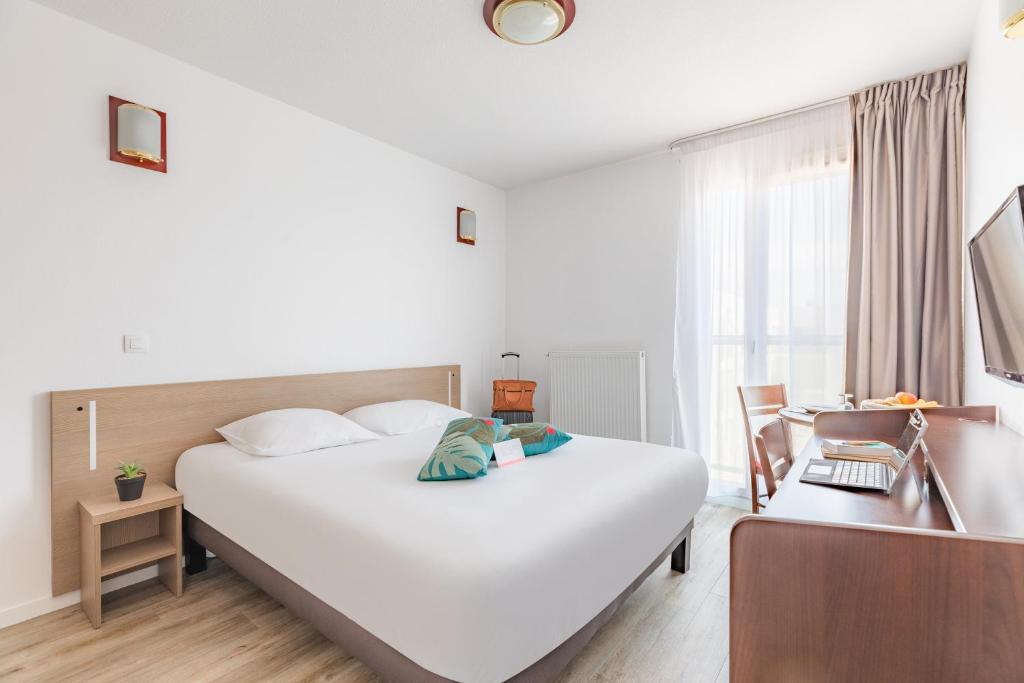 索恩河畔沙隆Appart'City Classic Chalon sur Saone的酒店客房设有一张白色大床和一张书桌