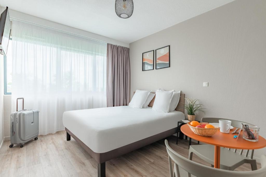 波尔多Appart'City Classic Bordeaux Centre的酒店客房配有一张床铺和一张桌子。