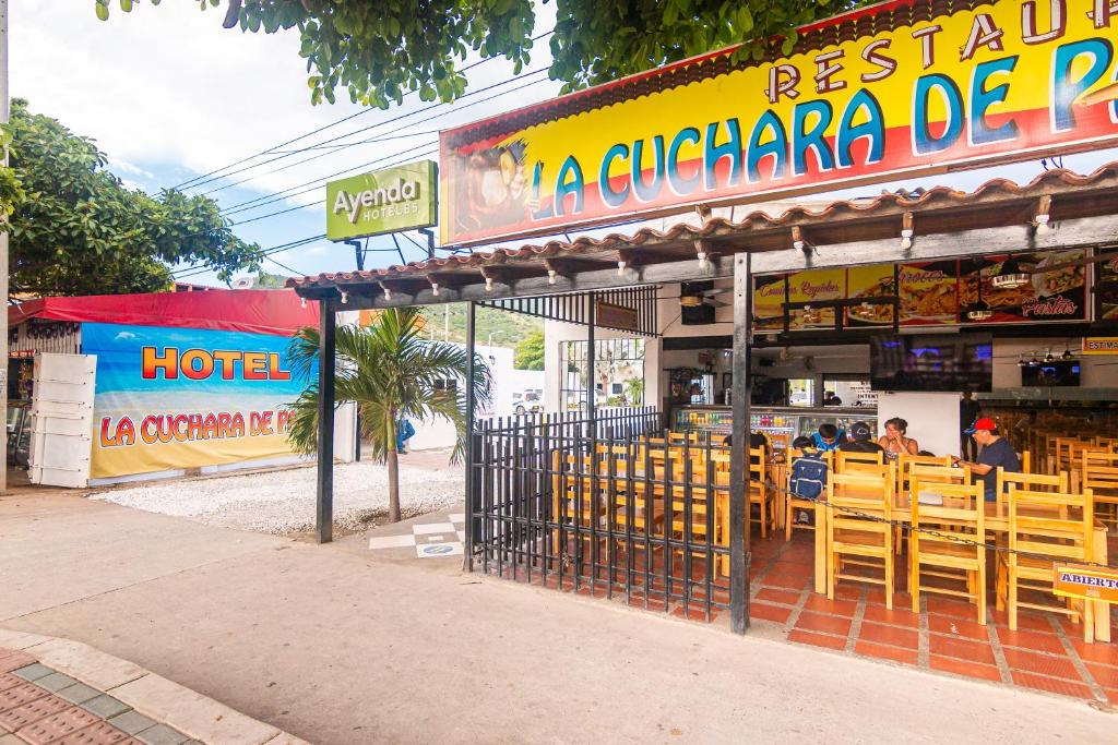 圣玛尔塔Hotel Cuchara de Palo Ayenda的餐厅前面设有木桌和椅子