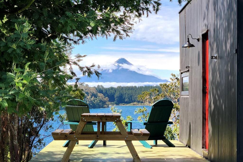 弗鲁蒂亚尔Exclusiva Cabin en tranquilo campo a orillas del lago con vista a volcanes - hot tub privado的山景甲板上的桌椅