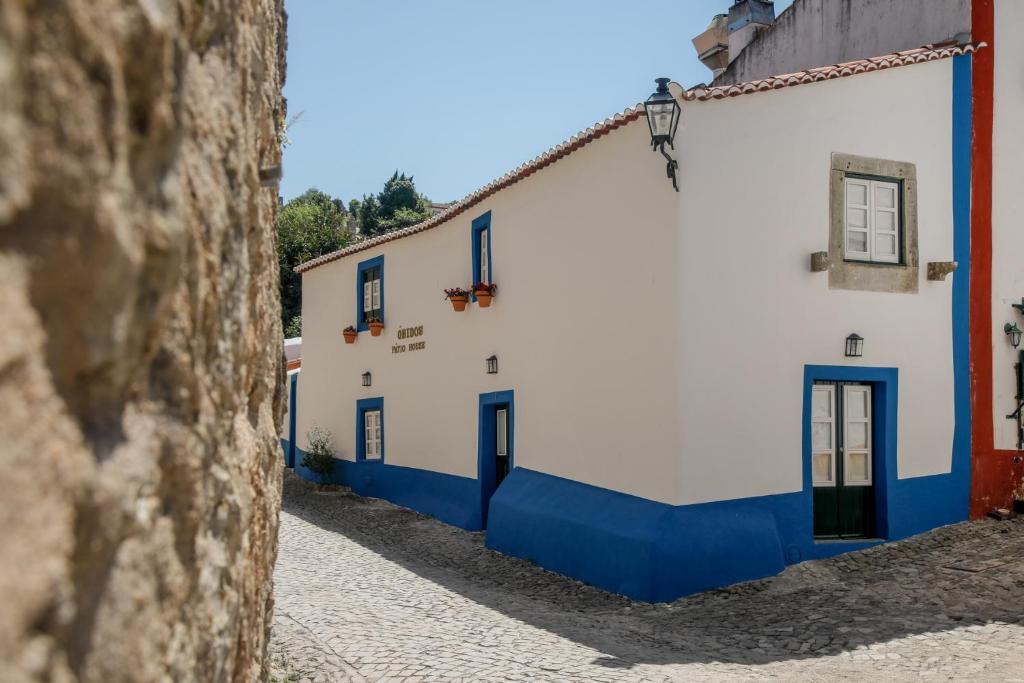 奥比多斯Óbidos Pátio House的街道上一排白色和蓝色的建筑