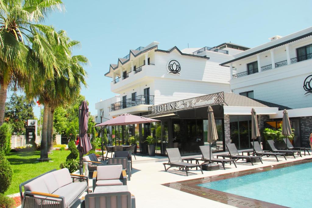 凯麦尔Edem Flower Hotel的一个带游泳池和椅子的度假胜地和一座建筑