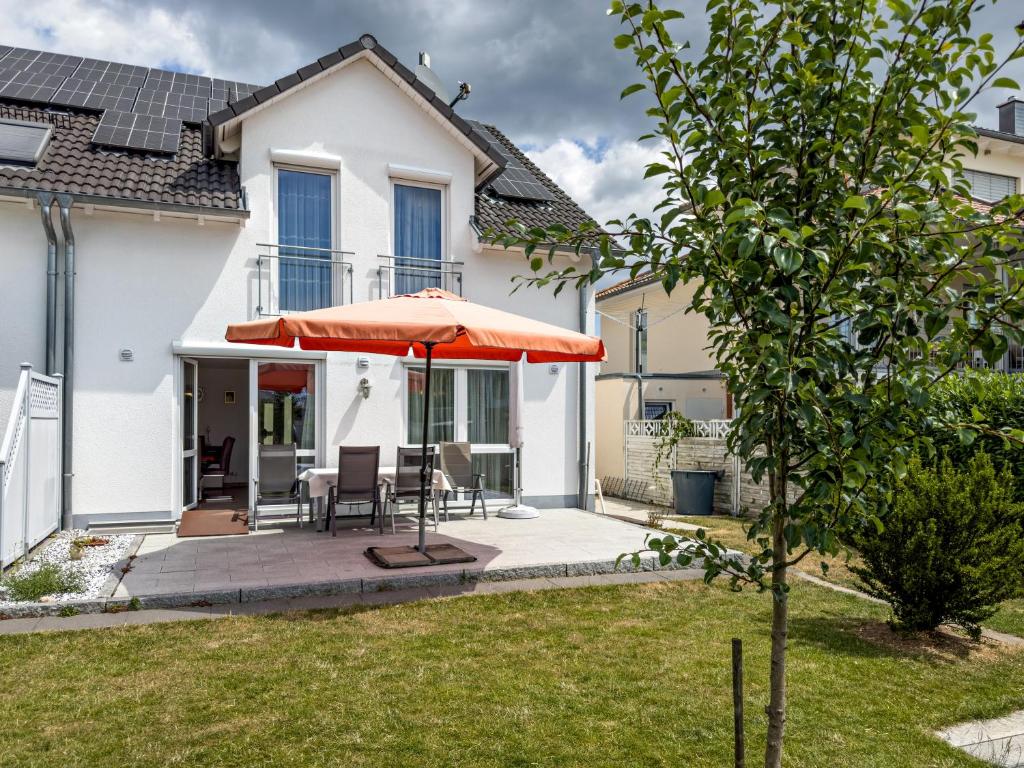 马克多夫Storchennest的一座带庭院和橙色遮阳伞的房子