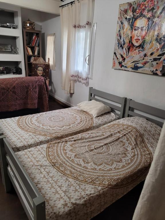 CeyresteLe toit du monde的卧室内的两张床,墙上有绘画作品
