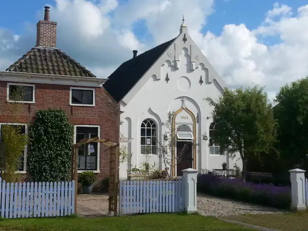 ZeerijpKerkje De Kleine Antonius的白色和红色的房子,有白色的栅栏