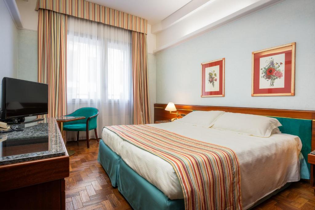 米兰克里维斯酒店的配有一张床和一台平面电视的酒店客房