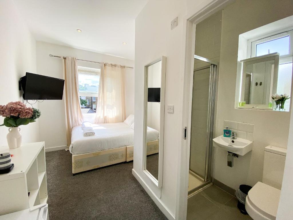 伦敦Wembar Hotel的一间卧室配有床、水槽和镜子