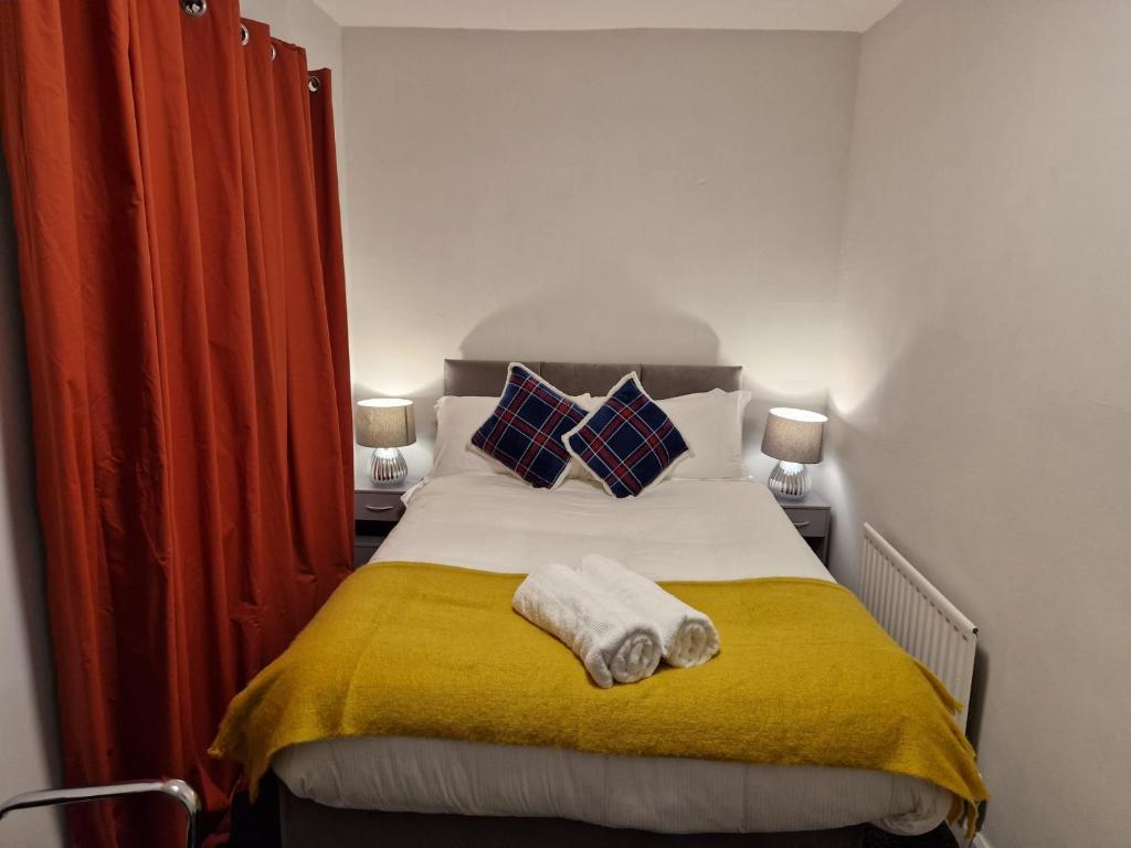 切斯特勒斯特里特Chester Le Street's Emerald 3 Bed House的一间卧室配有一张带黄色毯子和枕头的床。