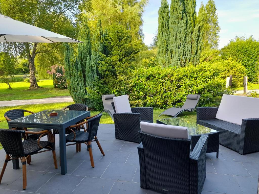 吕村Domaine de l'Ermitage的庭院配有桌椅和遮阳伞。