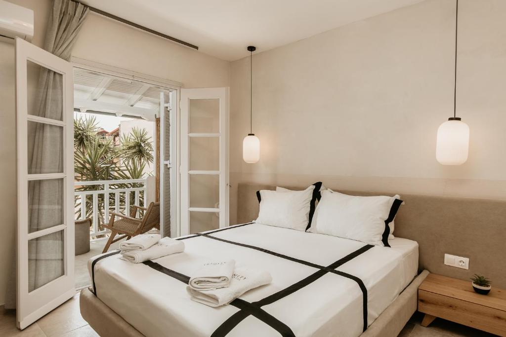 阿莫利亚尼岛TRINITY THE HOTEL的一间卧室配有一张大床和两条毛巾