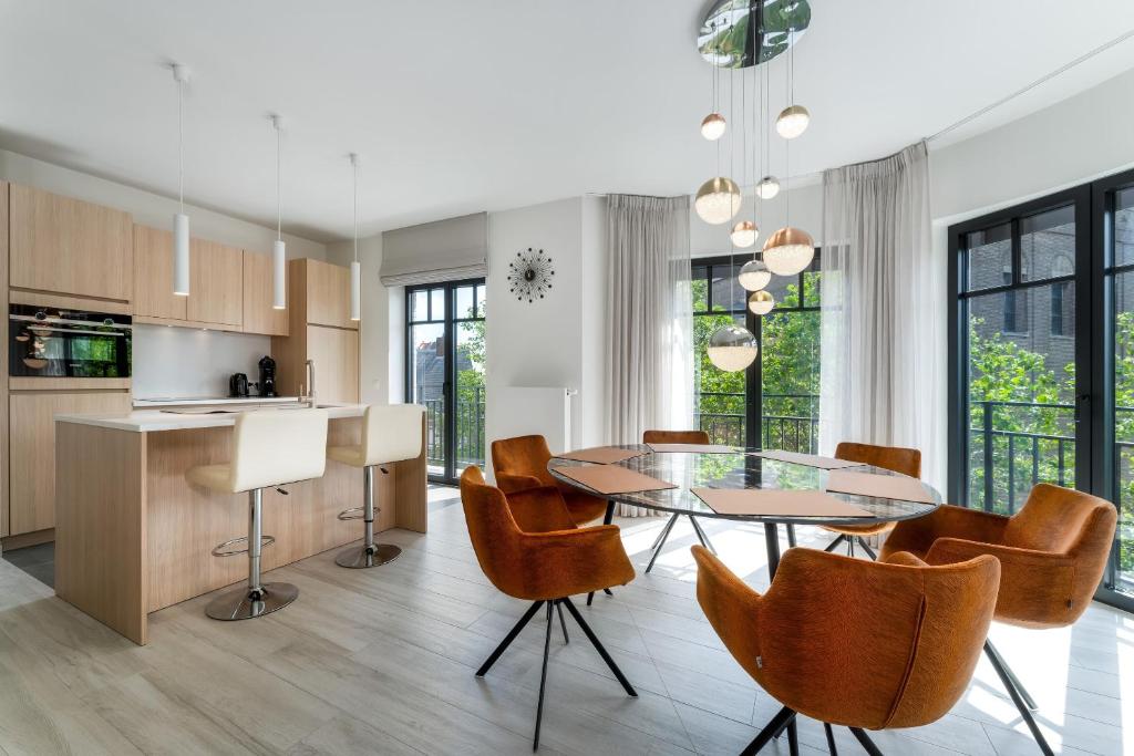 克诺克－海斯特Zonnig Luxueuze Appartementen La Coronne的厨房以及带玻璃桌和椅子的用餐室