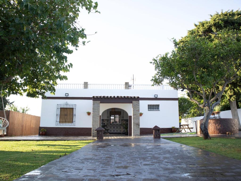 奇克拉纳－德拉弗龙特拉Villa Alegría的白色的建筑,有鹅卵石车道