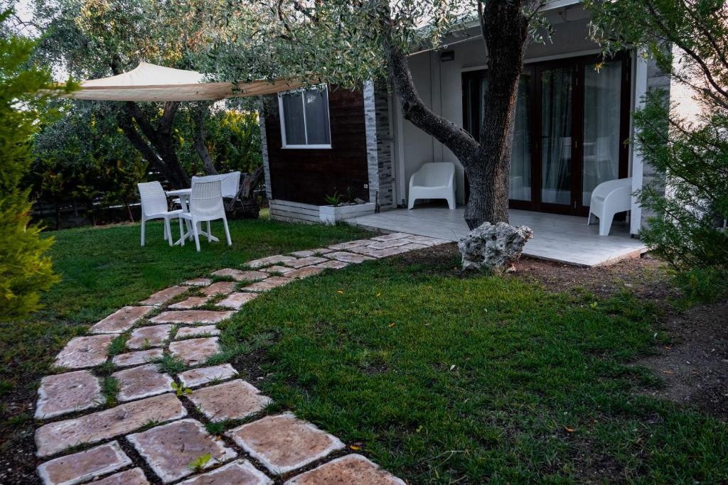 马蒂纳塔Giardino Don Berardino的庭院里设有带椅子和遮阳伞的庭院。