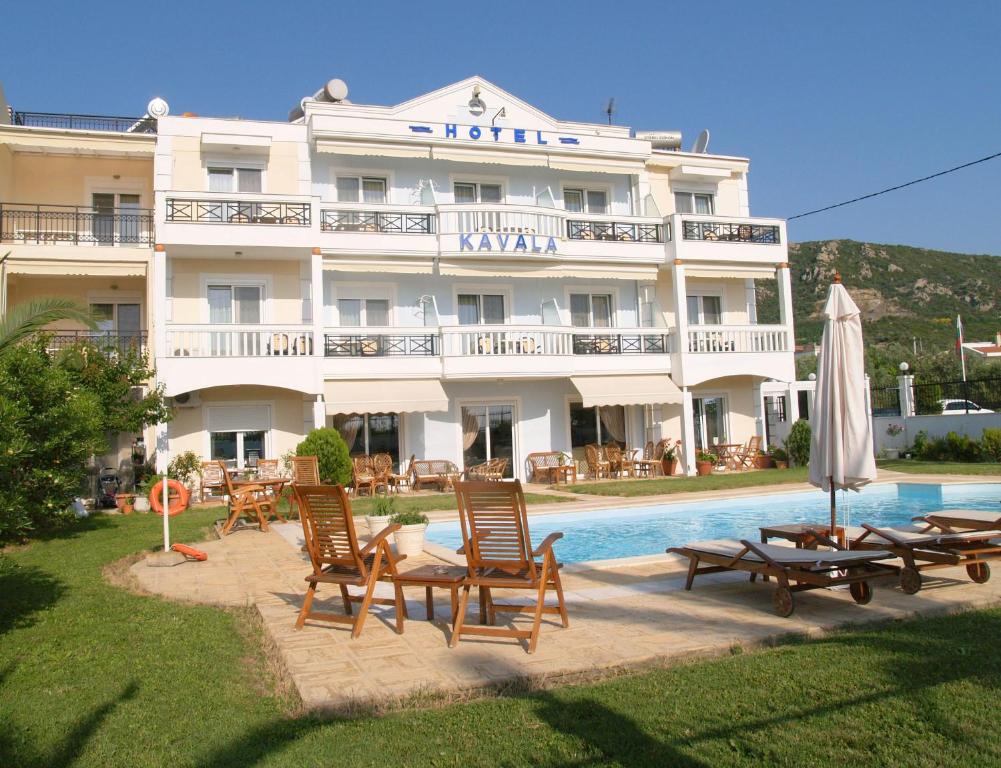 伊拉克里萨Kavala Beach Hotel apartments的一座配有椅子的酒店,酒店前方设有一个游泳池