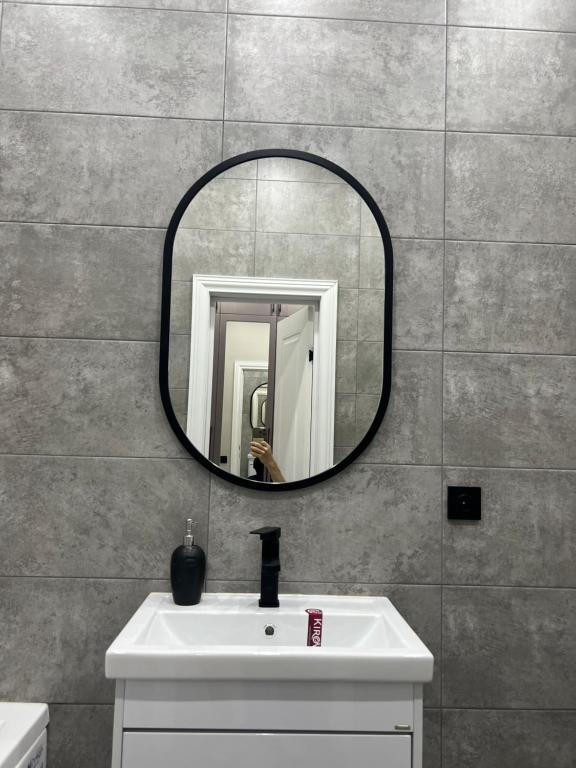 阿克托比Люксовая Квартира的浴室设有水槽和墙上的镜子