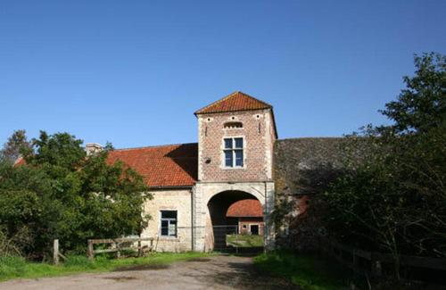 HaachtB&B Kraneveld的一座古老的石头建筑,有塔楼和门
