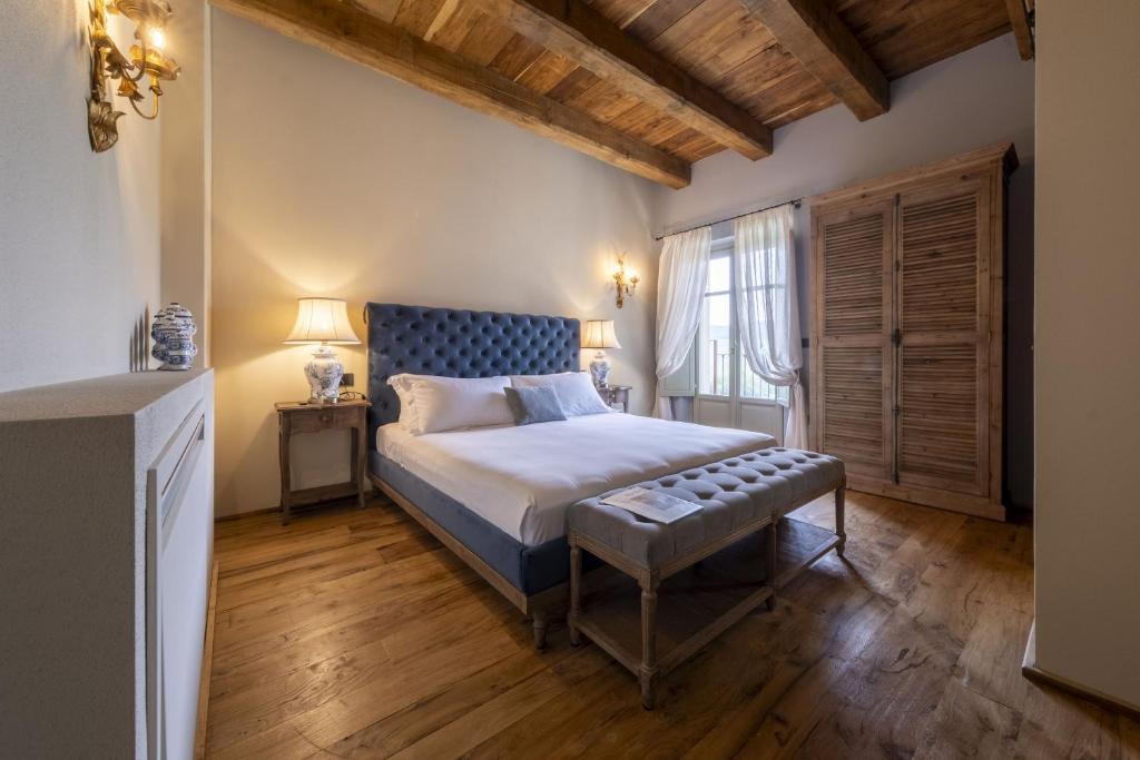 蒙福特达尔巴Tenuta Bussia - Wine Relais & Spa的一间卧室配有一张特大号床,铺有木地板
