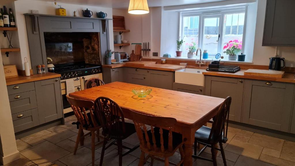 韦茅斯Blue Ensign Cottage的厨房配有木桌和一些椅子