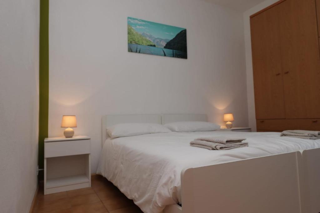 莱维科特尔梅Appartamento Valentina的一间卧室配有一张白色床和两盏灯。