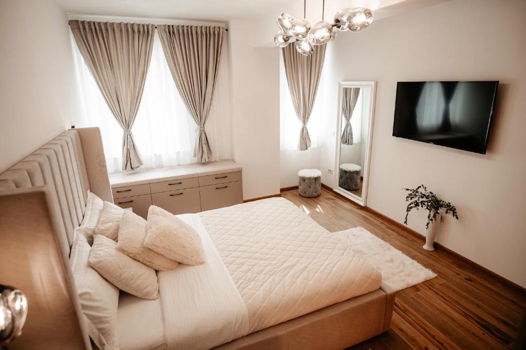 苏恰瓦Cosy apartment Bucovina的卧室配有一张白色大床和电视。