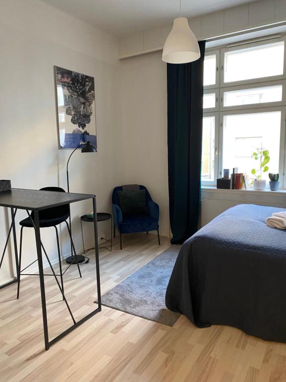 赫尔辛基Wonder studio apartment prime location and commute in the heart of Kallio的一间卧室配有一张床、一张书桌和一个窗户。