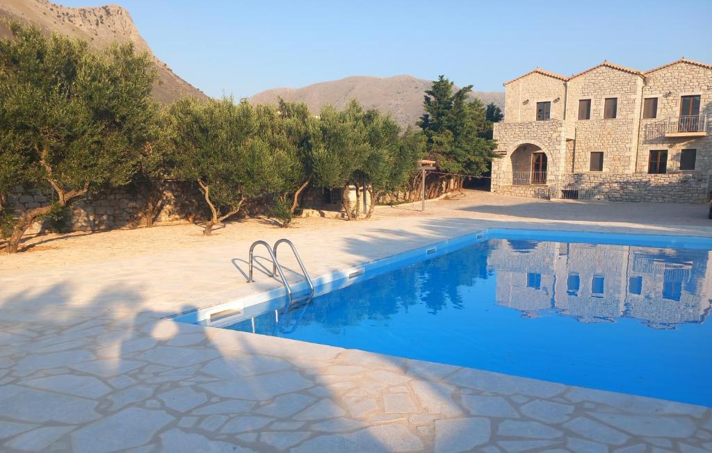 阿里奥波利斯库库里套房旅馆的一座带建筑物的房子前的游泳池