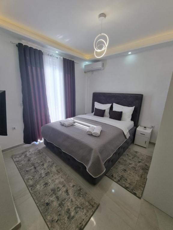 乌尔齐尼Kahari Apartments的一间卧室配有一张大床和两条毛巾