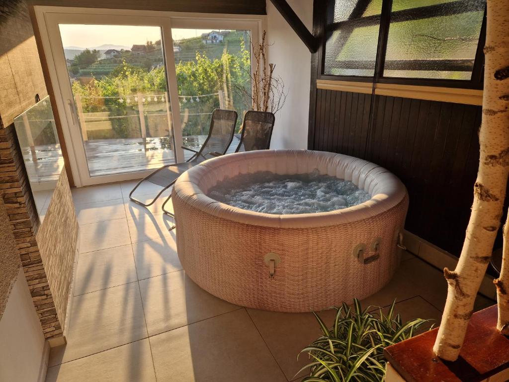 梅特利卡Vineyard Holidays Cottage with Jacuzzi的庭院内的大型浴缸配有两把椅子