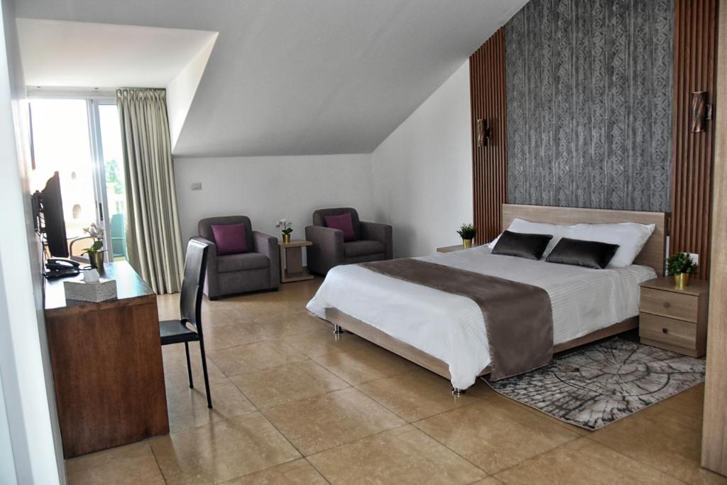 朱拜勒拜布洛斯之星酒店的卧室配有一张床、一张桌子和椅子