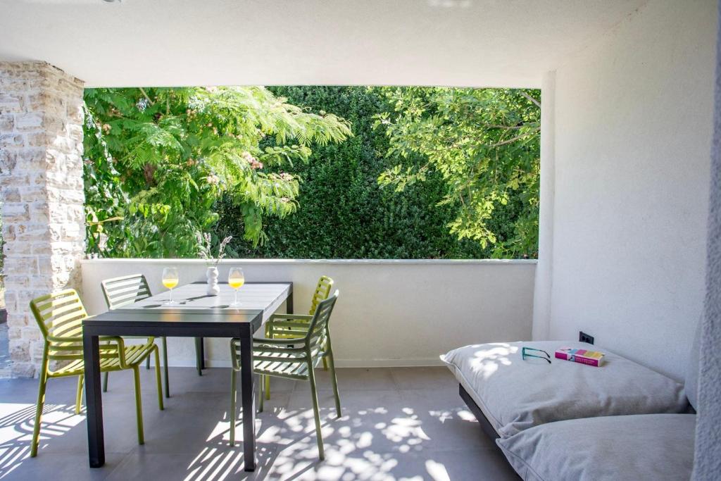帕科坦Villa Favi的阳台配有桌椅和窗户