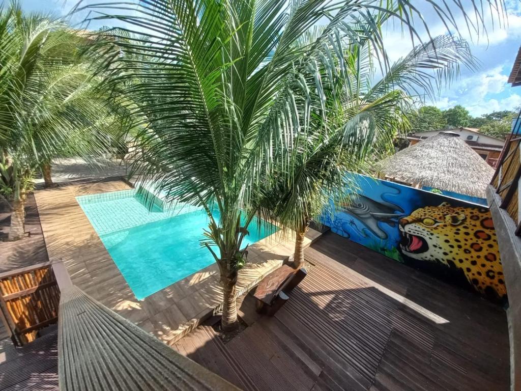 阿尔特杜尚Pousada Tupaiú的棕榈树和游泳池的度假村