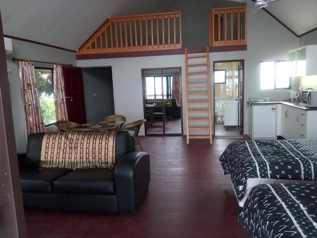 辛加东卡Seaside Villa的带两张床和一张沙发的房间以及一间厨房