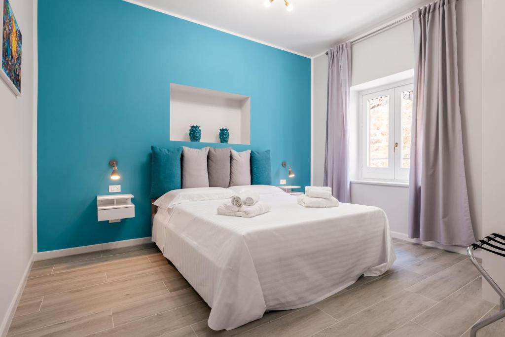 巴勒莫LE PORTE DEL KASSARO的蓝色的卧室设有一张蓝色墙壁的大床