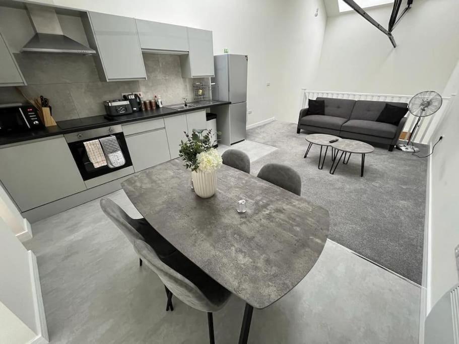 罗瑟勒姆Modern Loft Apartment的厨房以及带桌子和沙发的客厅。