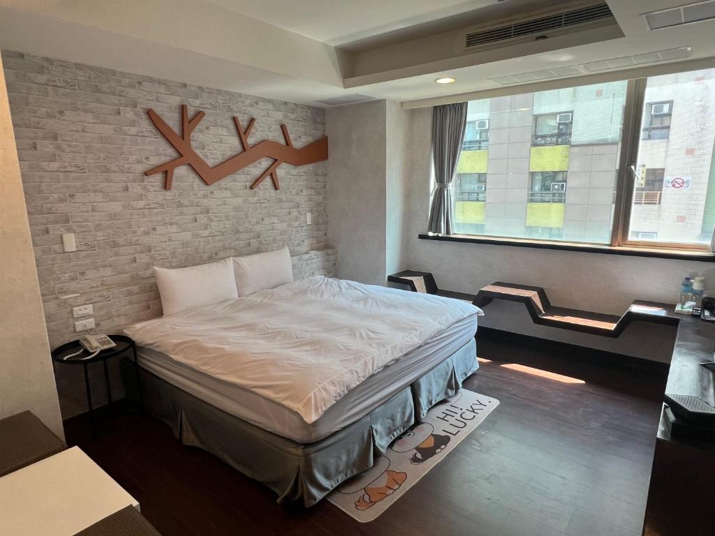礁溪凯丽温泉饭店的一间卧室设有一张床和砖墙