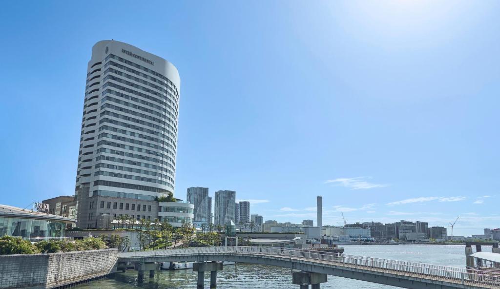 东京东京湾洲际酒店的一座高大的建筑,靠近一条有桥的河流