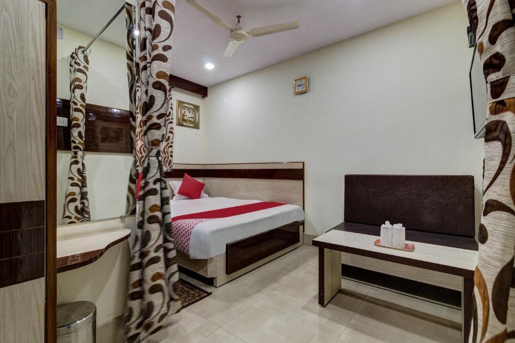 贾姆谢德布尔OYO Hotel Satguru的卧室配有一张床和一张桌子